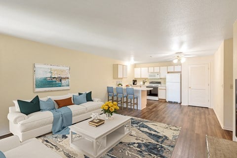 a living room and kitchen with a white couch and a coffee table